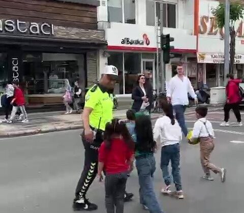 Trafik polisi trafiği kesti, çocukları karşıdan karşıya geçirdi